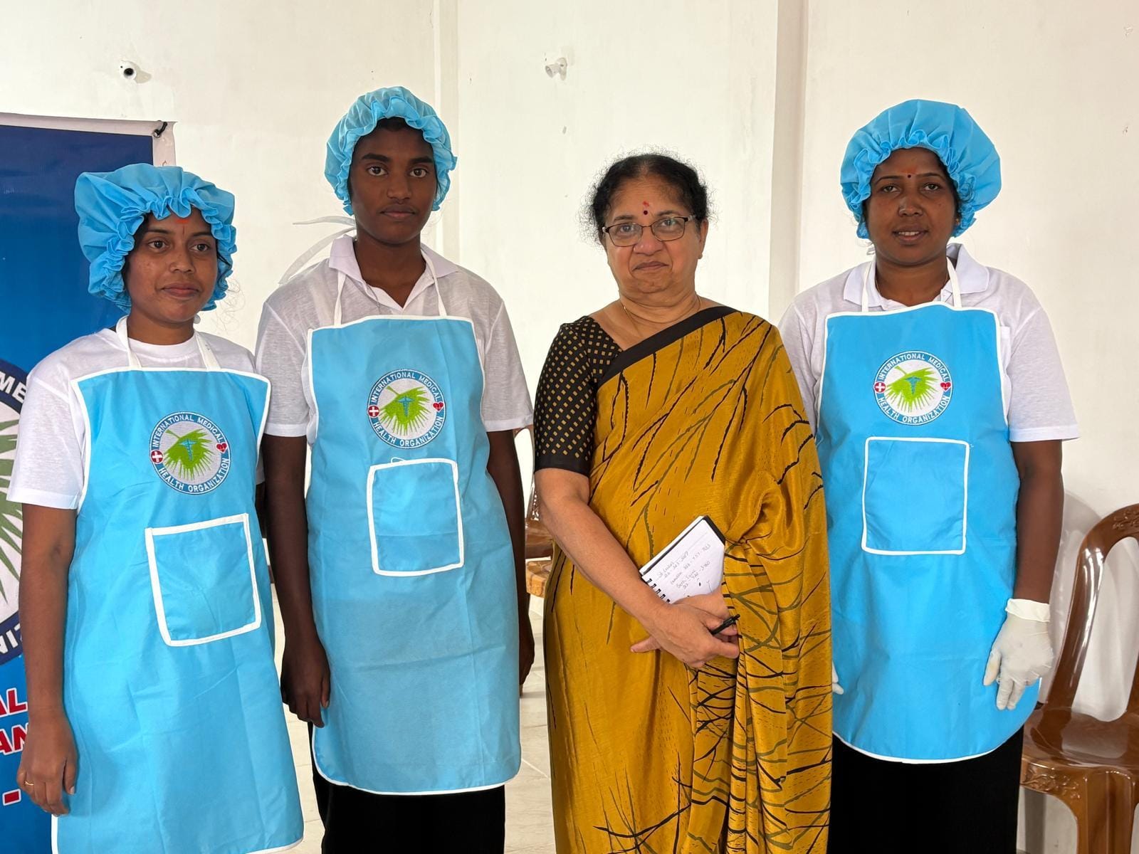 Dr. Rajam Theventhiran (third from left) with staff at an IMHO vocational training center in Sri Lanka’s upcountry region. Women in blue aprons produce sanitary pads as part of the initiative.
